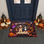 A personalized Halloween doormat displayed in front of a dark blue door, decorated with pumpkins, lanterns, and fall leaves. The mat features a custom design with a golden retriever and a black cat dressed as witches, the text 'Witch Better Have Treats', and the names 'Beasley and Oliver'.