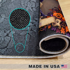 A rolled black pet mat with a Halloween-themed printed design showing pumpkins, autumn leaves, and a paw print, displayed on a light wood floor. A circular inset highlights the textured black and white pattern on the mat's surface.