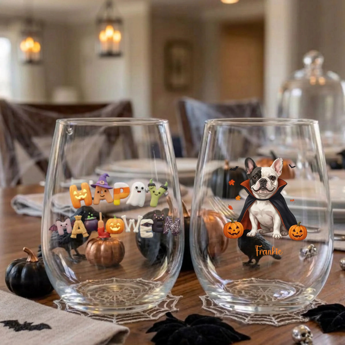 Pair of personalized Halloween stemless wine glasses with a vampire-costume dog with pumpkins on a dining table set for a Halloween party