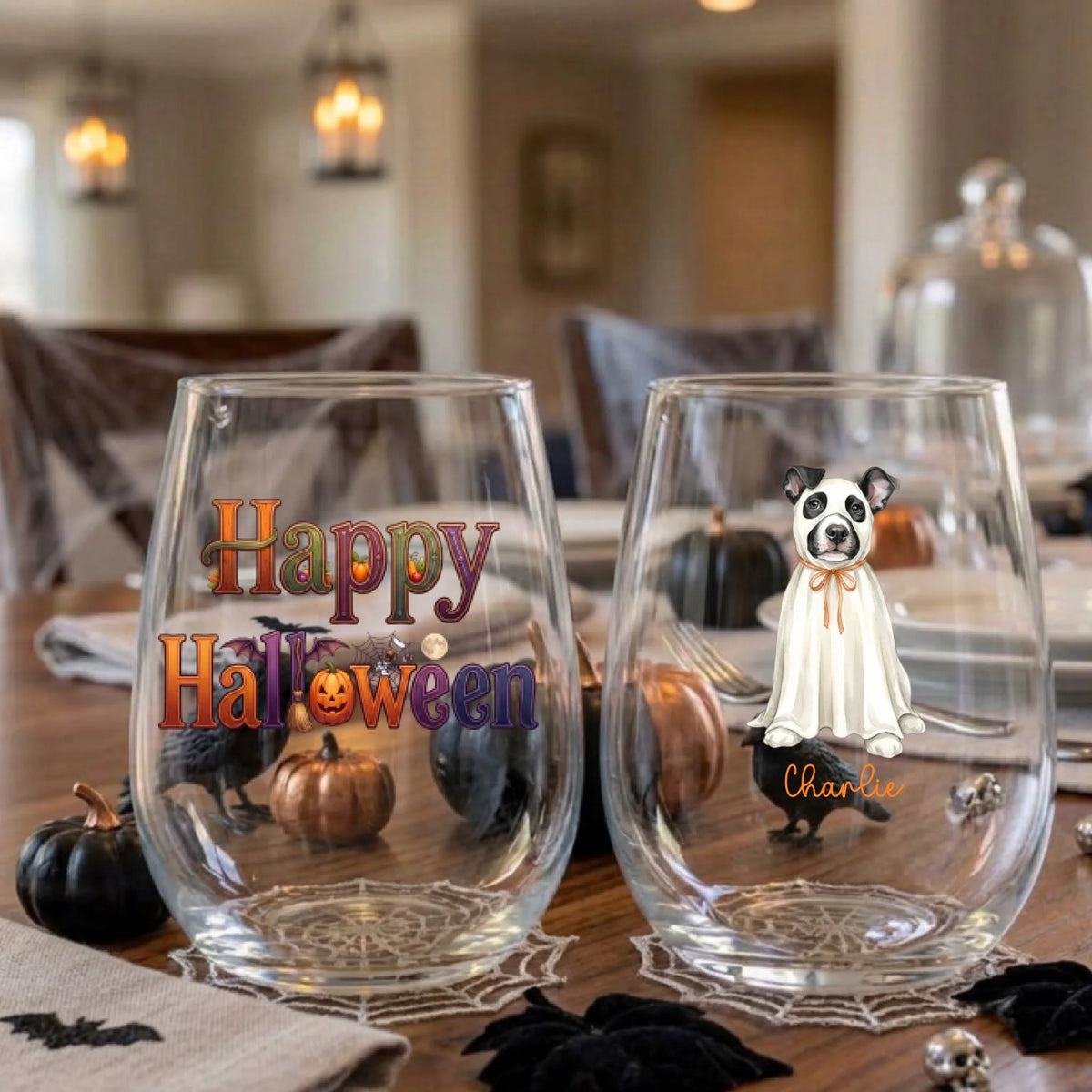 Pair of personalized Halloween stemless wine glasses with a watercolor ghost-costume dog on a dining table set for a Halloween party