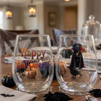 Pair of personalized Halloween stemless wine glasses with a watercolor vampire-costume dog on a dining table set for a Halloween party