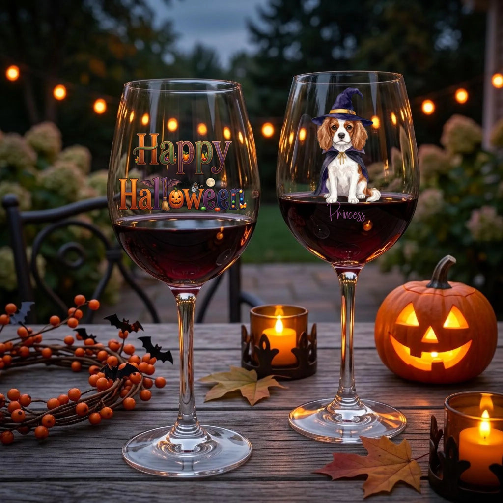 Witch dog and Happy Halloween wine glasses on an outdoor table with a jack-o'-lantern and candles