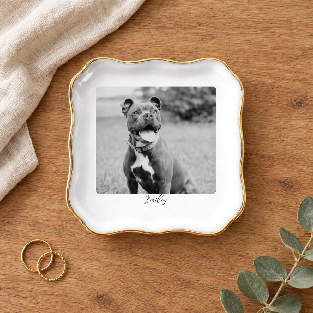 Black and white pet photo wavy square ring dish on a wooden table with linen and eucalyptus