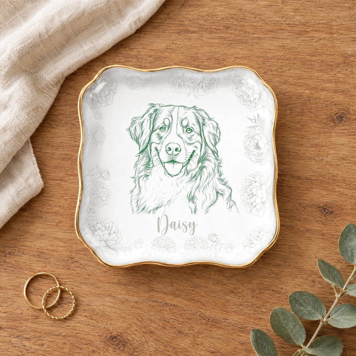Wavy square floral pet sketch ring dish styled on a wooden table with linen