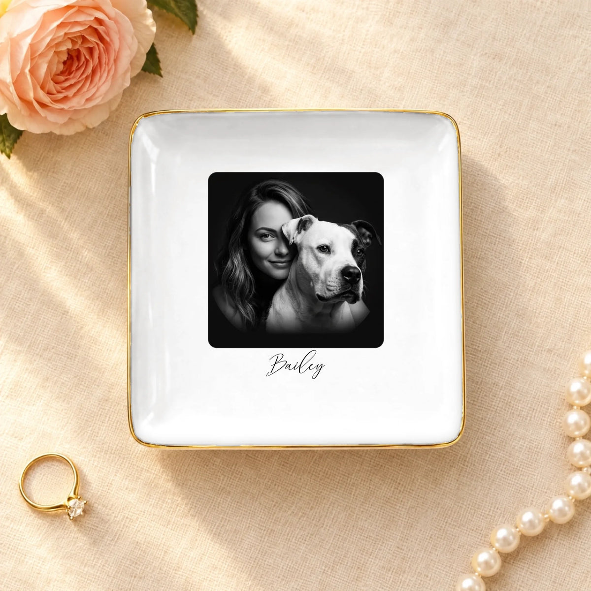 Black and white studio portrait of owner and pet on a square ceramic ring dish with gold rim