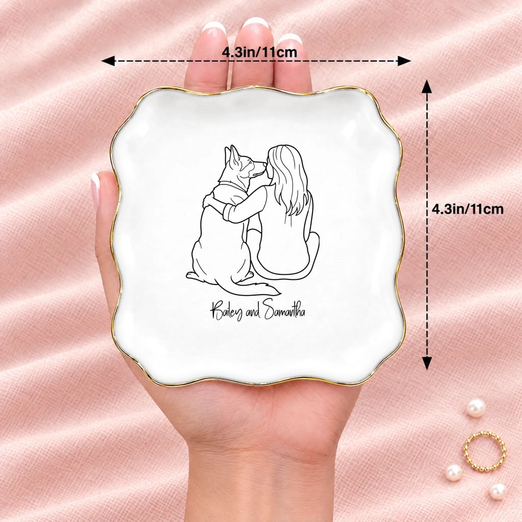 Hand holding a line drawing person and dog wavy square ring dish, 4.1 inches across
