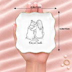 Hand holding a line drawing person and dog wavy square ring dish, 4.1 inches across