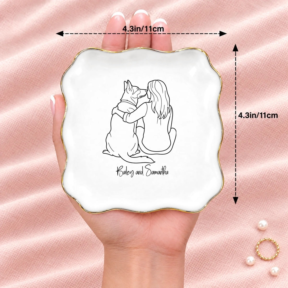 Hand holding a line drawing person and dog wavy square ring dish, 4.1 inches across