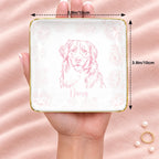 Square floral pet sketch ring dish resting on an open hand, 3.9 inches across