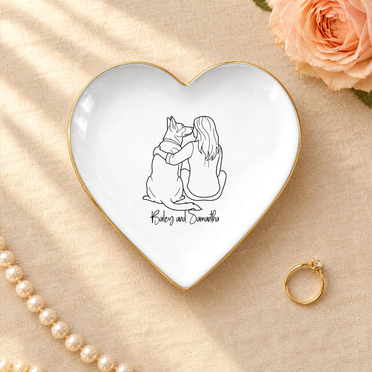Personalized line drawing of a woman and her dog on a heart ceramic ring dish with gold rim