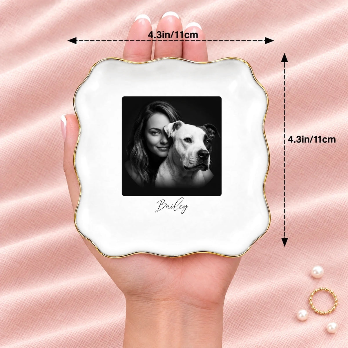 Hand holding a black and white studio portrait wavy square ring dish, 4.1 inches across