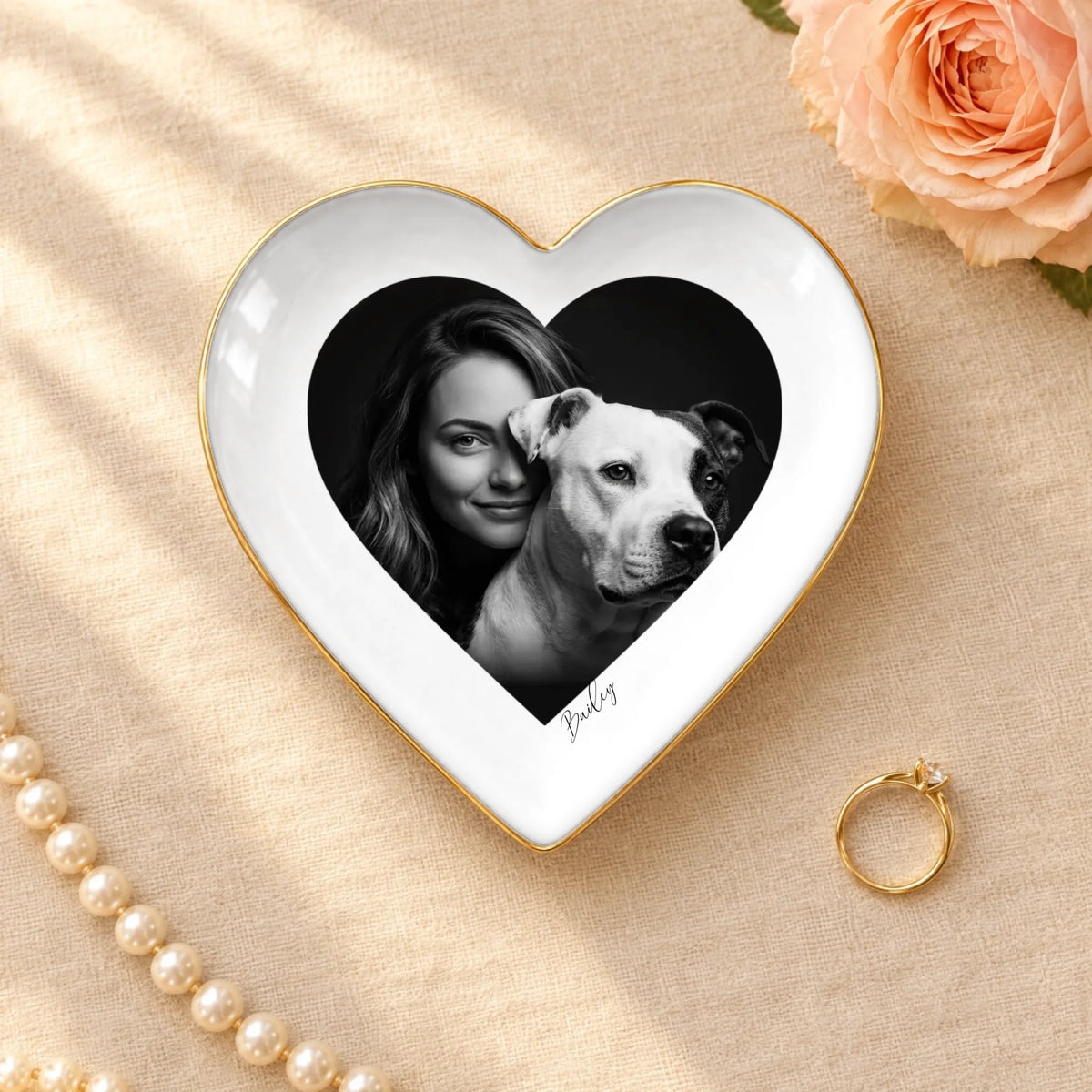 Black and white studio portrait of owner and pet on a heart ceramic ring dish with gold rim