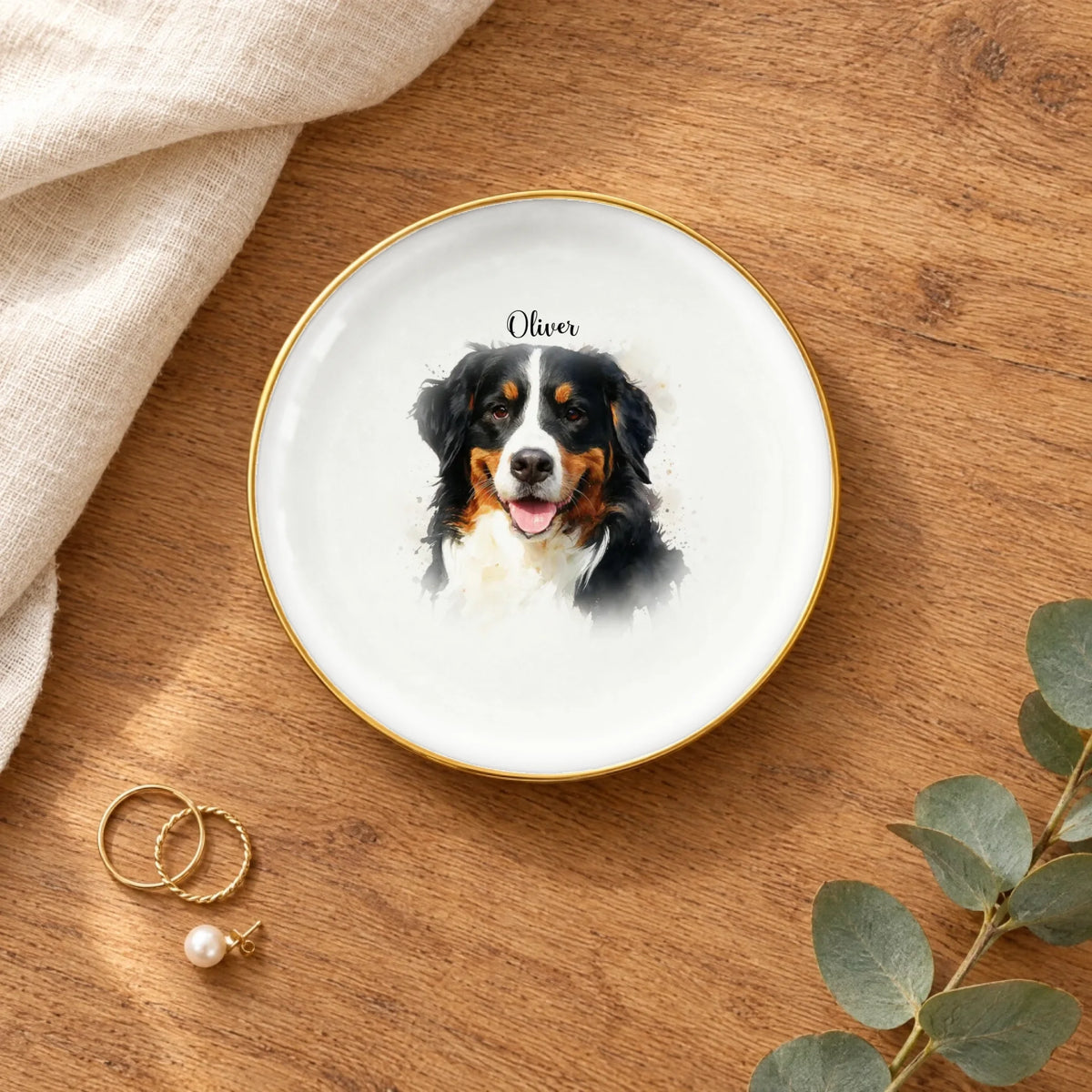 Round watercolor splash pet portrait ring dish on a wooden table with linen and eucalyptus
