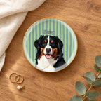 Round striped pet portrait ring dish on a wooden table with linen and eucalyptus