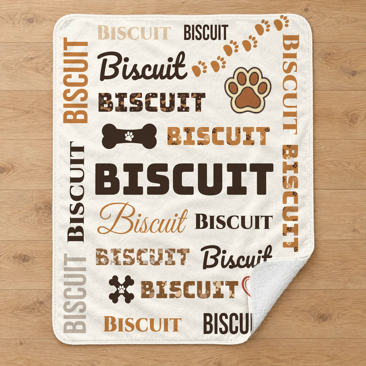 Personalized dog name word cloud sherpa blanket laid flat on an oak floor, showing the full design with paw prints, bones and treat jar