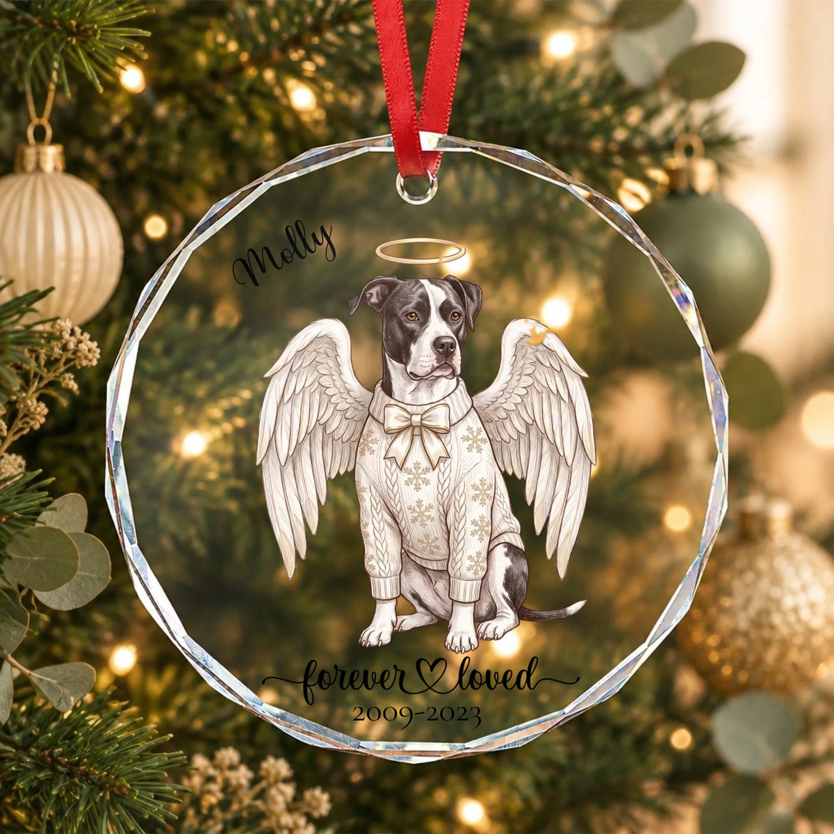 Personalized pet angel glass ornament with their name, halo and wings, hanging on a softly lit Christmas tree