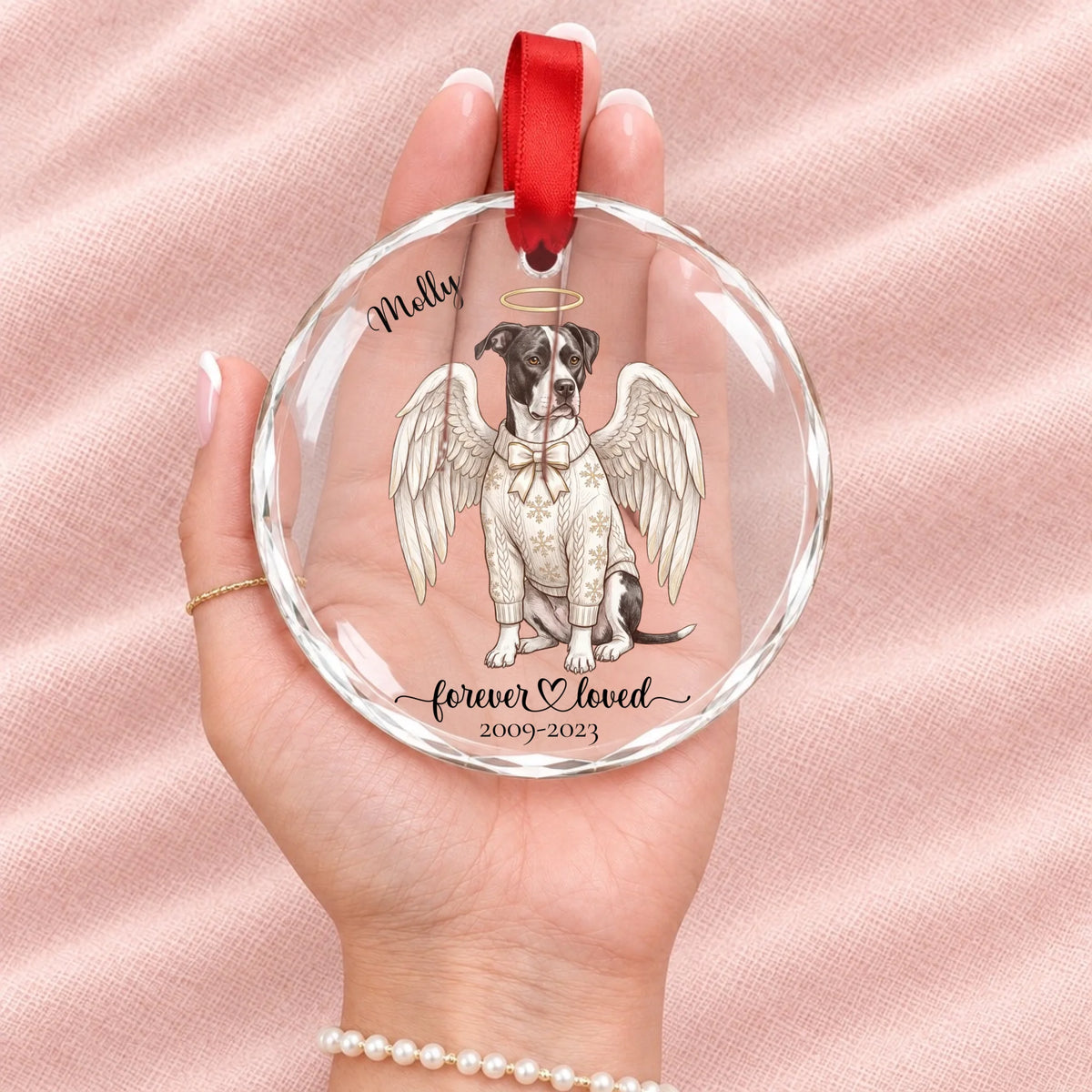 Forever Loved pet angel glass ornament resting in an open hand to show its size