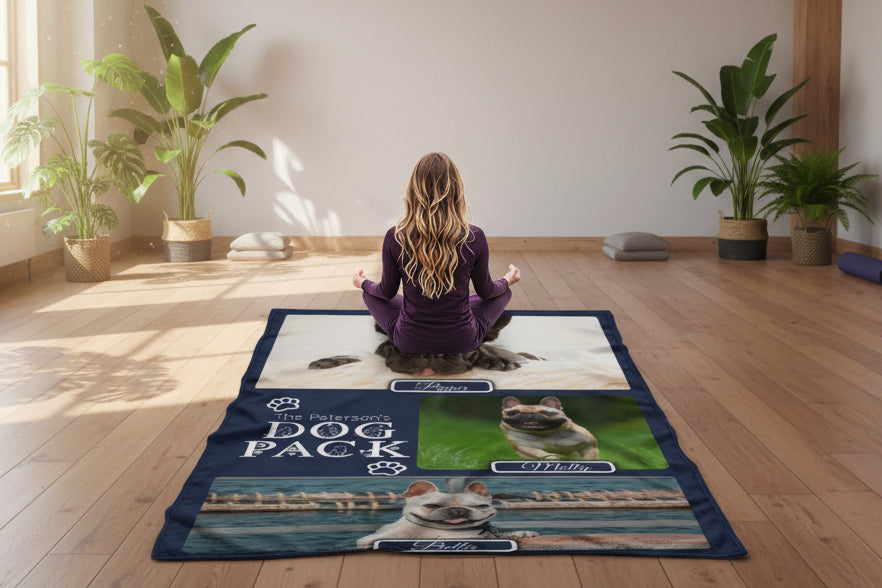 Person sitting on a beach with a personalized dog blanket featuring images of dogs and text.