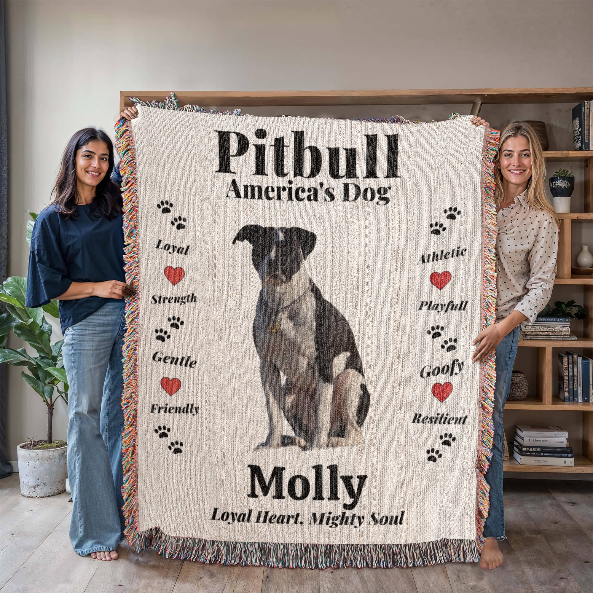 Two people holding a woven blanket with a Pitbull design and text about the breed.