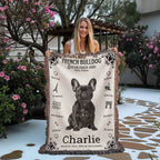 A woman holding a French Bulldog-themed woven blanket with 'Charlie' on it outdoors.Personalized with the name and photo of your Frenchie.