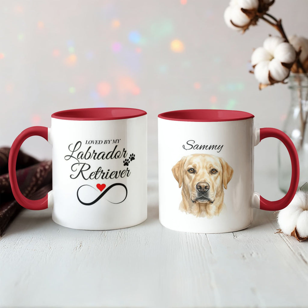 Two mugs with red interiors and handles, one featuring a Labrador Retriever and the other with text, on a light surface.
