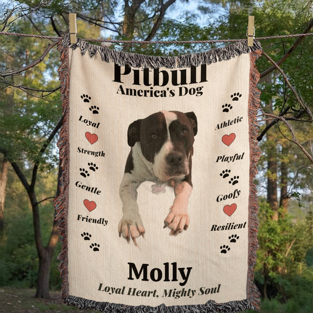 woven Blanket with a Pitbull illustration and text about the breed, hanging outdoors.
