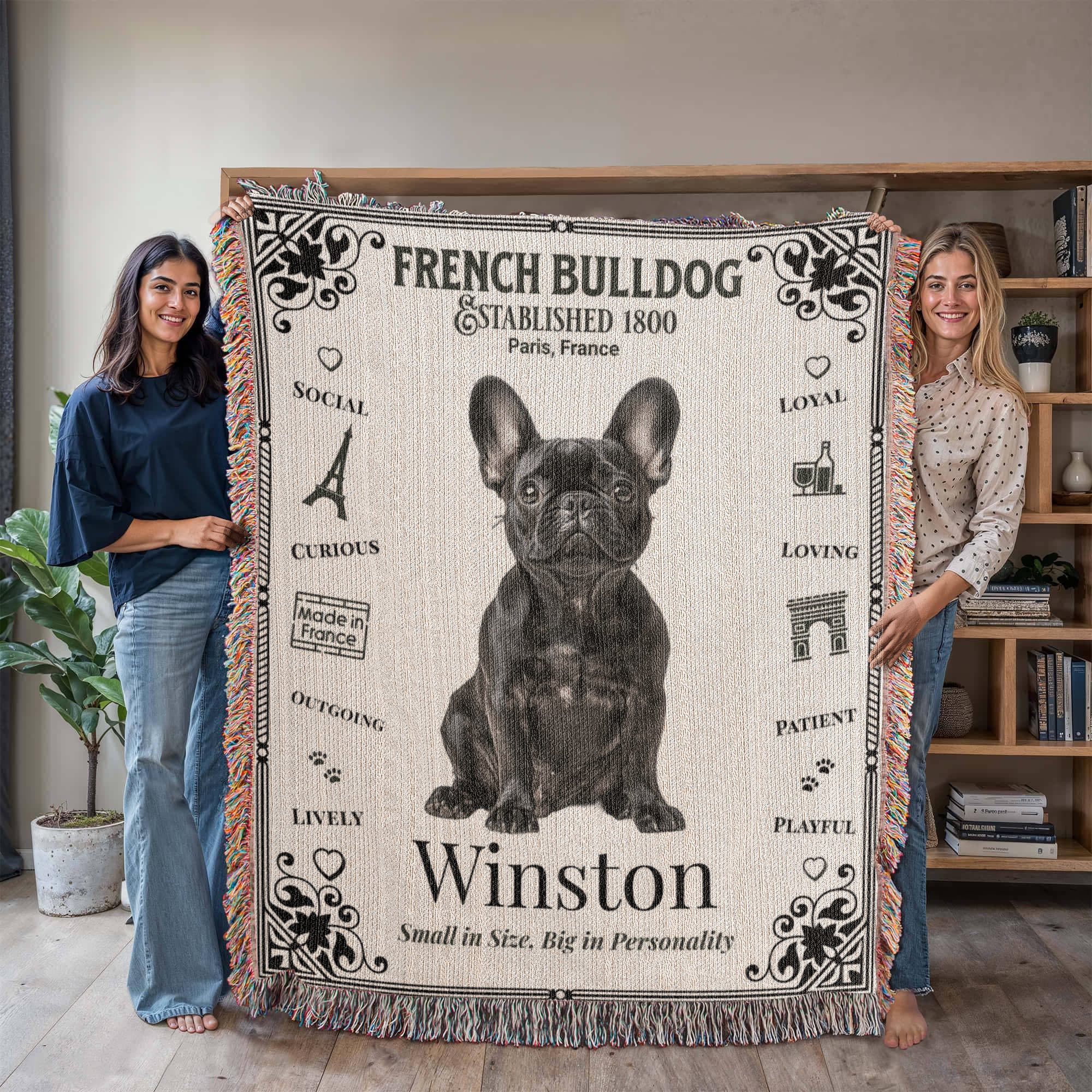 Two people holding a French Bulldog-themed woven blanket with the name 'Winston'.Personalized with the name and photo of your Frenchie.