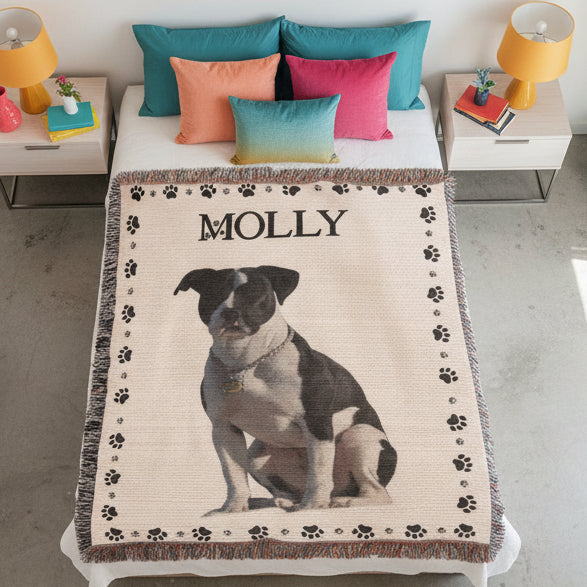 Blanket with a dog's photo and name 'Molly' on a bed in a room.