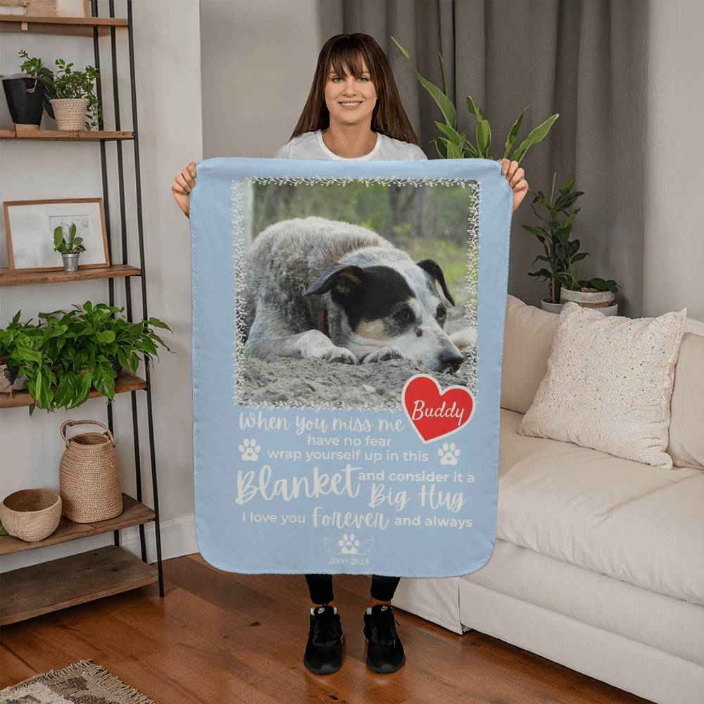 Person holding a personalized blanket with a dog's photo and text in a living room.