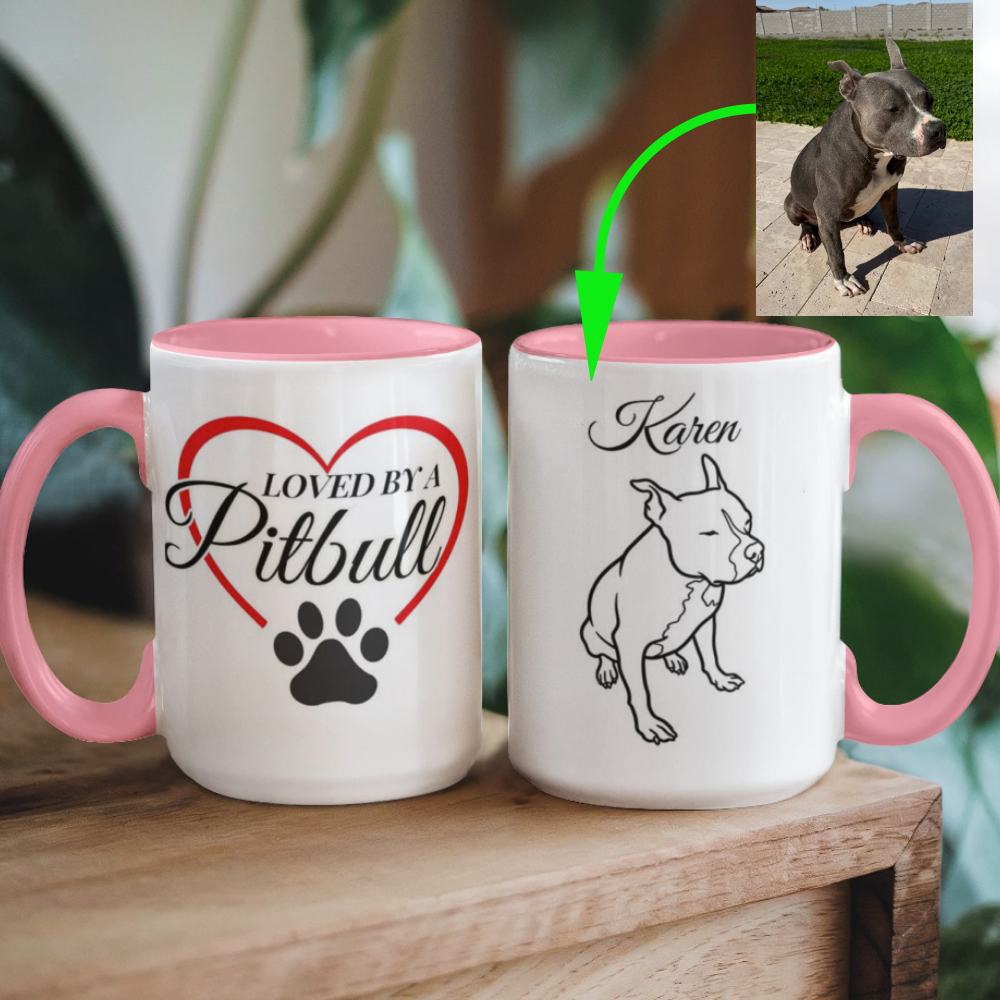 Two mugs with dog-themed designs on a wooden surface, one with 'Loved by a Pitbull' and the other with a pitbull illustration.