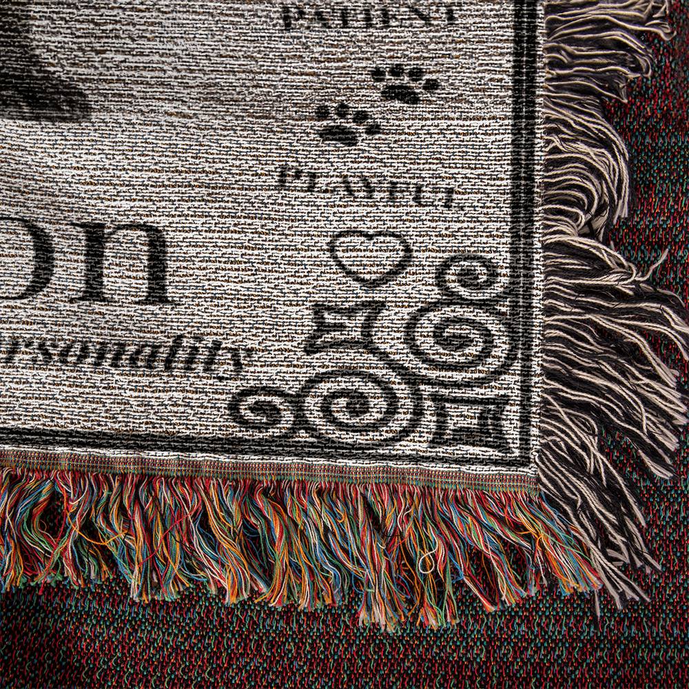 Textured fabric with printed text and graphics, featuring a paw print and decorative elements.