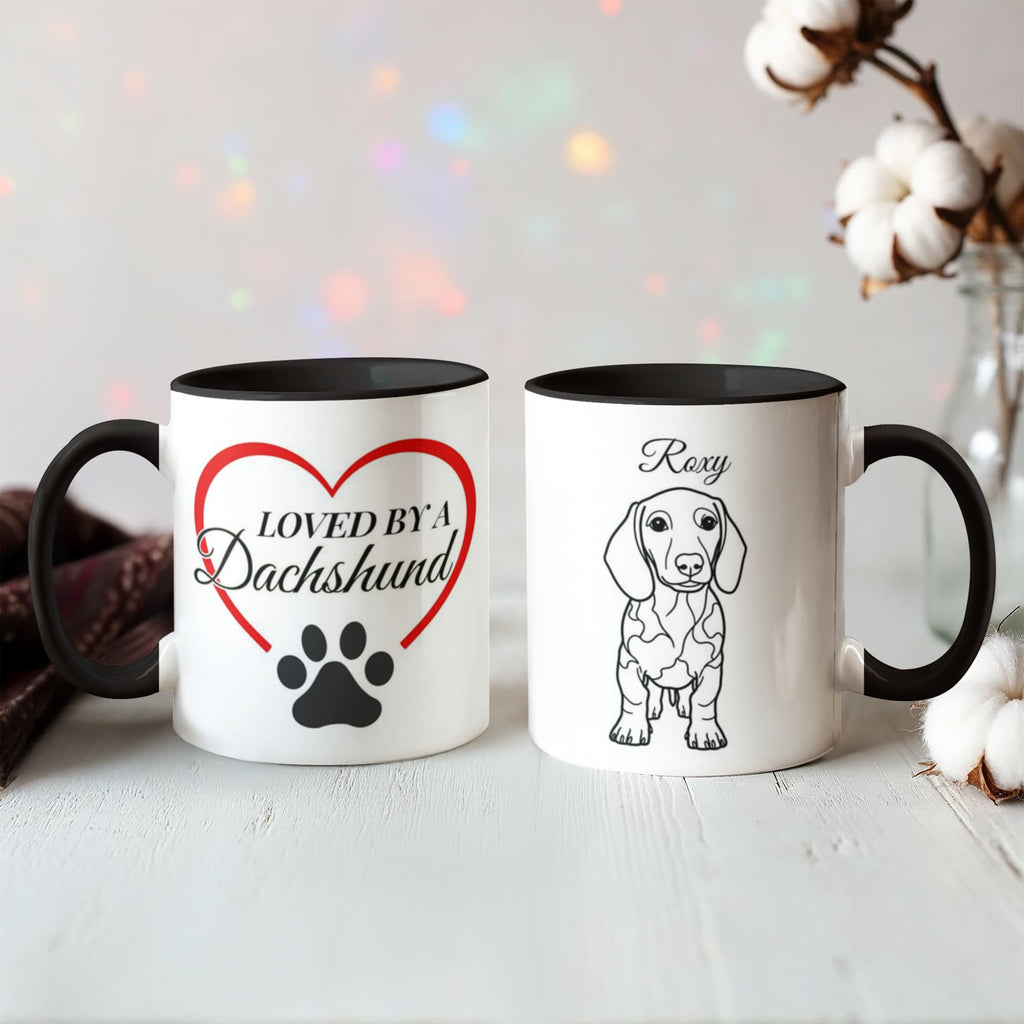 Two mugs with a dachshund design on a light surface with decorative lights and cotton in the background.