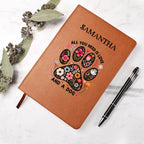 Brown notebook with floral paw design and text, accompanied by a pen on a light background.