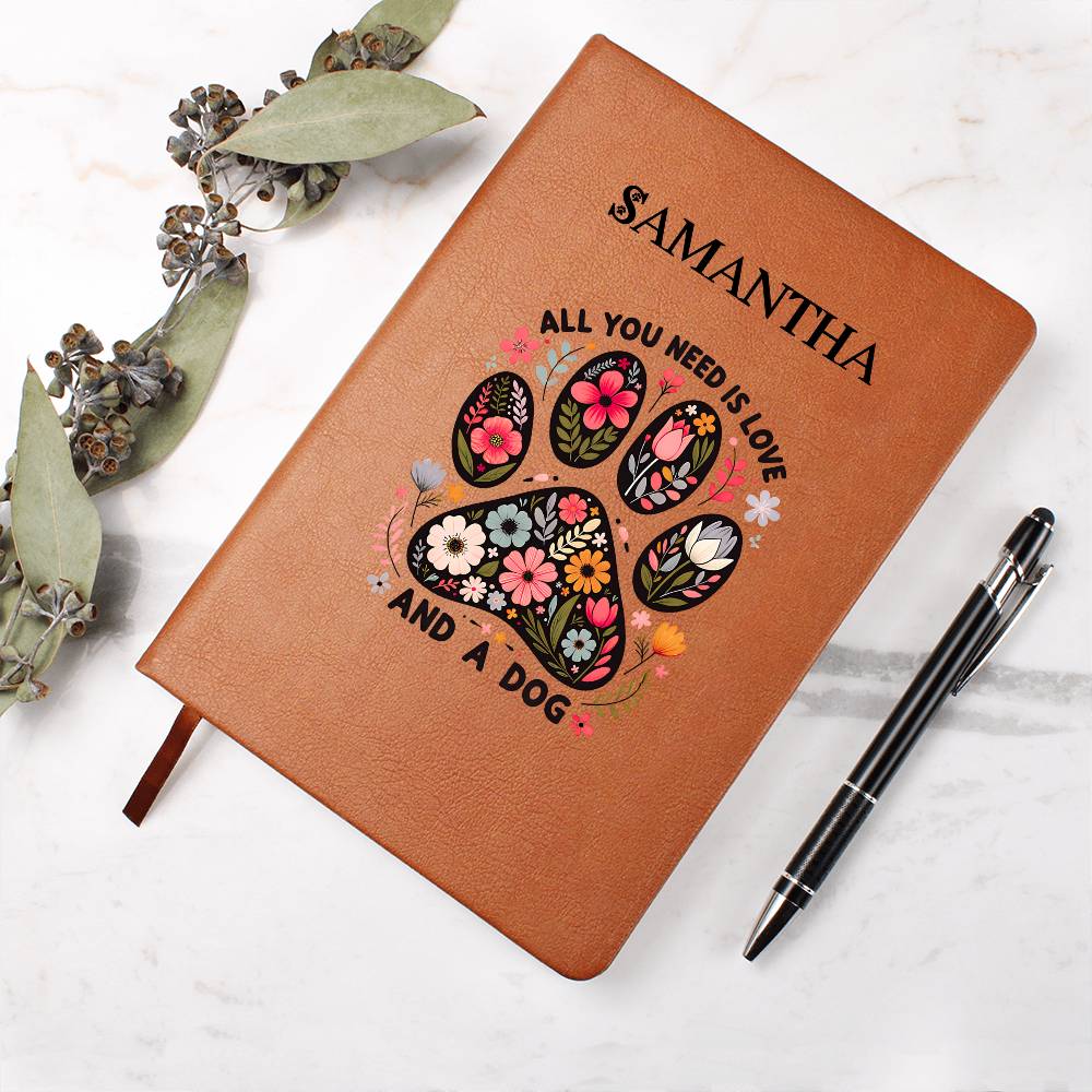Brown notebook with floral paw design and text, accompanied by a pen on a light background.
