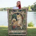 Person holding a Shiba Inu-themed blanket by a lake