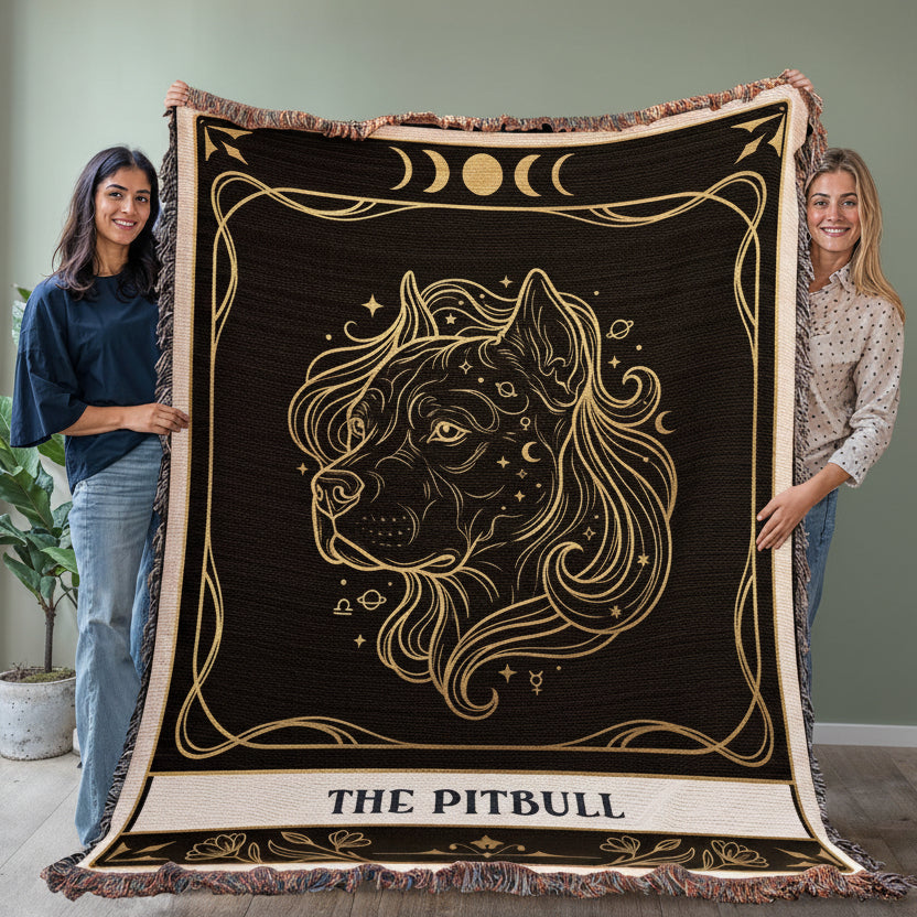 Two people holding a decorative blanket with a pitbull design against a plain wall.