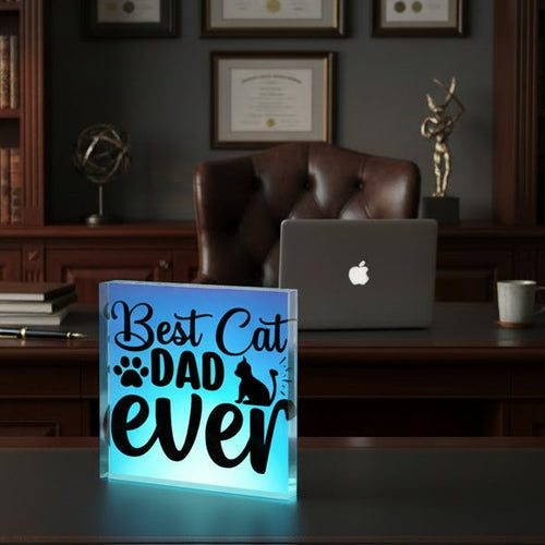Glowing sign with 'Best Cat Dad Ever' on a desk in an office setting