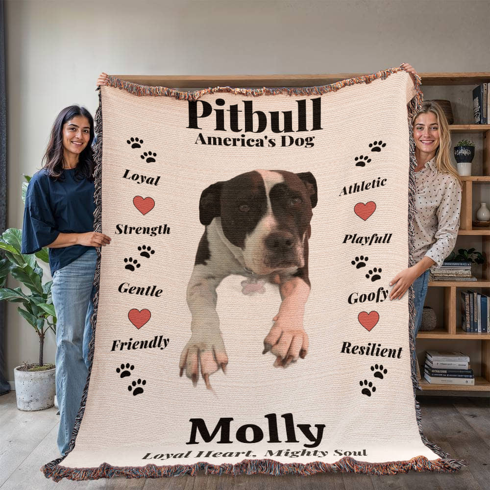 Two people holding a blanket with a pitbull design and text about the breed.