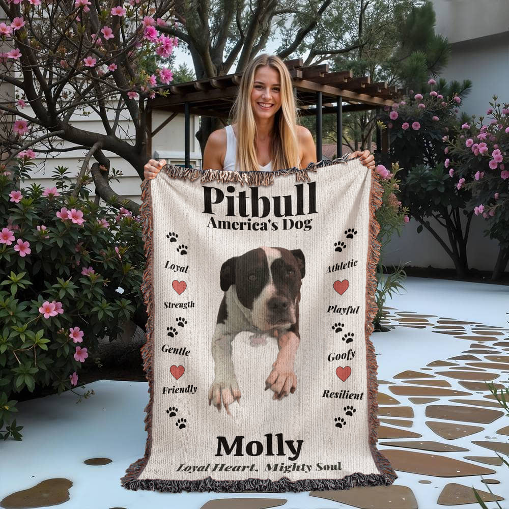 Woman holding a woven blanket with a pitbull design and text outdoors.