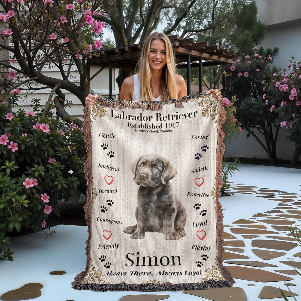 Woman holding a blanket with a Labrador Retriever design and text outdoors. Personalize your Labrador Retriever woven blanket with your dog's photo and name.