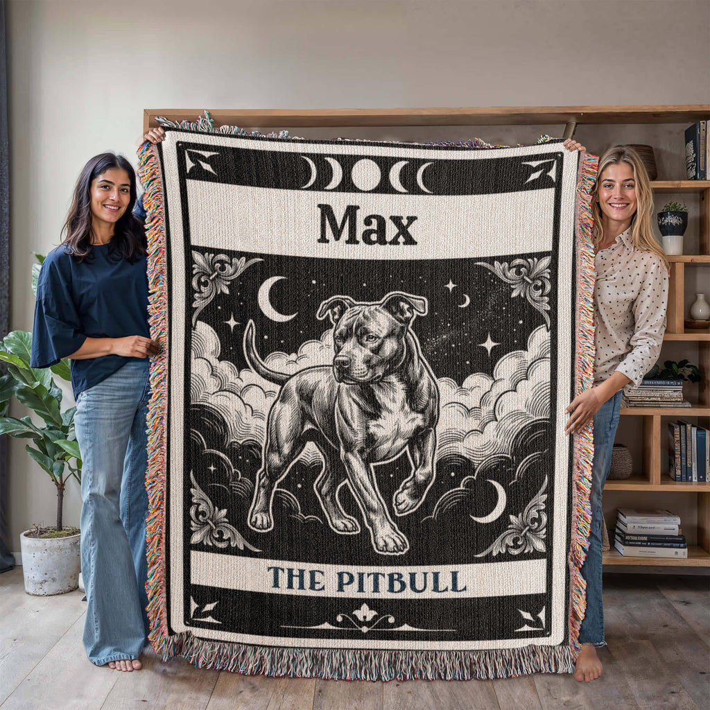 Two people holding a woven blanket with a dog tarot card illustration and text in a room.