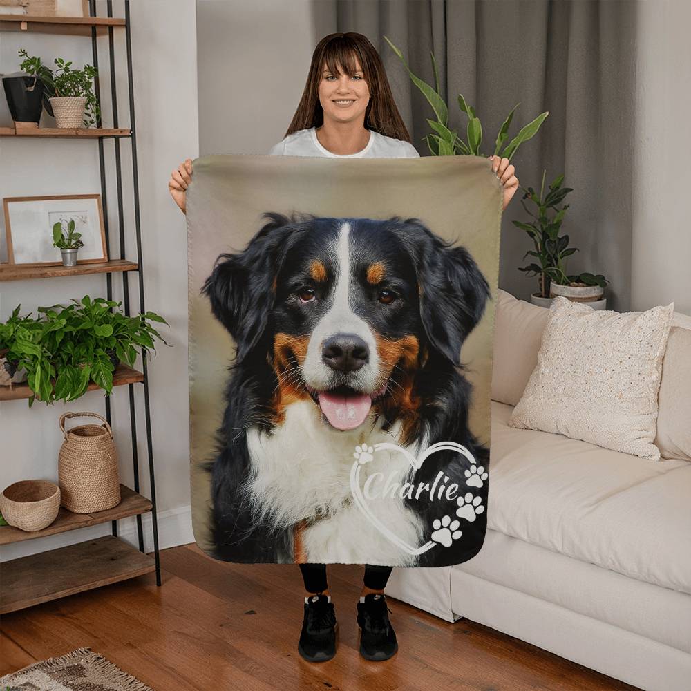Person holding a blanket with a dog's face and name 'Charlie' in a living room.
